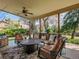 Relaxing covered patio with comfortable seating, ceiling fan, and views of the landscaped yard and lush green trees at 164 W Acoma Dr, Littleton, CO 80120