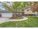 Charming home featuring a manicured front yard, brick accents, and a welcoming walkway to the front door at 164 W Acoma Dr, Littleton, CO 80120