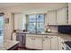 Well-lit kitchen showcasing granite countertops, stainless steel appliances, and a view of the backyard at 164 W Acoma Dr, Littleton, CO 80120