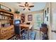 Office featuring custom wooden built-ins, a ceiling fan, and a glass door to the exterior at 164 W Acoma Dr, Littleton, CO 80120