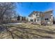 Expansive backyard with a wooden deck and patio with mature landscaping and partial snow cover at 1642 S Trenton St, Denver, CO 80231