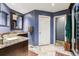 Blue bathroom with a granite countertop, dark wood vanity, and glass shower at 1642 S Trenton St, Denver, CO 80231