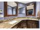 This bathroom features a granite countertop, framed mirrors, and stylish dark wood cabinetry at 1642 S Trenton St, Denver, CO 80231