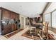 Kitchen with dark wood cabinets, stainless steel appliances, and a round wood dining table at 1642 S Trenton St, Denver, CO 80231