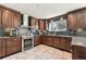 Elegant kitchen with stainless appliances, granite countertops, and dark wood cabinets at 1642 S Trenton St, Denver, CO 80231