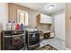 Functional laundry room with modern washer and dryer, plus built-in cabinets at 1642 S Trenton St, Denver, CO 80231