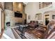 Inviting living room featuring a stone fireplace, high ceilings, and comfortable leather seating at 1642 S Trenton St, Denver, CO 80231