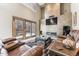 Bright living room with stone fireplace, leather couches, and sliding glass doors to the backyard at 1642 S Trenton St, Denver, CO 80231