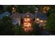 Aerial view of a brick two-story home with a landscaped backyard and seating area at dusk, surrounded by trees at 1007 N Ogden St, Denver, CO 80218