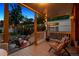 View of a covered back porch with comfortable seating, string lights, and lush landscaping, creating an inviting outdoor space at 1007 N Ogden St, Denver, CO 80218