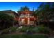 Landscaped backyard at dusk with string lights and a seating area with chairs on a two-story brick house at 1007 N Ogden St, Denver, CO 80218