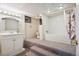 View of a unique bathroom featuring a raised tub with a shower, vanity, toilet, carpeted steps, and neutral wall color at 1007 N Ogden St, Denver, CO 80218
