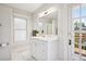 Bright bathroom with white vanity, marble countertop, and a view to the outdoor deck at 1007 N Ogden St, Denver, CO 80218