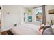 Bright bedroom showcasing natural light from a large window and neutral décor at 1007 N Ogden St, Denver, CO 80218