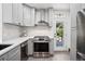Updated kitchen with stainless steel range, stylish backsplash, and modern cabinetry, opening to the yard at 1007 N Ogden St, Denver, CO 80218