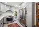 Modern kitchen featuring gray cabinets, stainless steel appliances, white countertops, and backsplash at 1007 N Ogden St, Denver, CO 80218