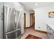 Galley kitchen with stainless steel refrigerator, modern white cabinets, and a view to the rest of the house at 1007 N Ogden St, Denver, CO 80218