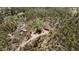 Scenic aerial view of a secluded property with a house, garage, outbuildings and surrounding dense forest at 8600 S Warhawk Rd, Conifer, CO 80433