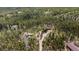 Wide aerial view of a charming home surrounded by a lush forest and various outdoor features at 8600 S Warhawk Rd, Conifer, CO 80433