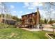 Charming wooden home featuring an outdoor deck, brick chimney, and a spacious lawn at 8600 S Warhawk Rd, Conifer, CO 80433