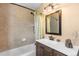 Well-lit bathroom with tub and shower, plus vanity with sink and decorative mirror at 8600 S Warhawk Rd, Conifer, CO 80433