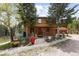Charming cabin with wood siding and a well-manicured front yard and front yard landscaping at 8600 S Warhawk Rd, Conifer, CO 80433