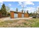 Spacious two-door garage with durable metal doors and gravel surround, near the house at 8600 S Warhawk Rd, Conifer, CO 80433