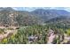 Beautiful property featuring a home nestled amongst lush green trees with mountain views at 11348 Ranch Elsie Rd, Golden, CO 80403