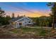 Inviting two-story home featuring a charming deck and picturesque mountain views at sunset at 11348 Ranch Elsie Rd, Golden, CO 80403