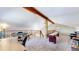 Open game room with wood beam, carpeted floor, and multiple game stations at 11348 Ranch Elsie Rd, Golden, CO 80403