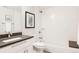 Modern bathroom featuring a combined tub and shower, white tile, and a dark vanity with modern fixtures at 801 8Th St, Golden, CO 80401