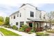 Modern two-story home with white siding, black windows, and covered front porch with landscaped yard at 801 8Th St, Golden, CO 80401
