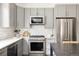 Bright kitchen with gray cabinetry, stainless steel appliances, white subway tile backsplash, and quartz countertops at 801 8Th St, Golden, CO 80401