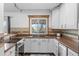 Modern kitchen with white cabinets, stainless steel appliances, and a breakfast bar at 8010 W Chestnut Dr, Littleton, CO 80128