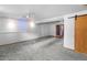 Living area featuring neutral walls, carpet floors, and a sliding wood door with beam at 8010 W Chestnut Dr, Littleton, CO 80128