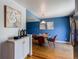 Dining room with stylish table set, hardwood floors, blue accent wall, and butler's pantry at 6839 E Briarwood Dr, Centennial, CO 80112