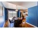 Dining room with stylish table set, hardwood floors, blue accent wall, and patio access at 6839 E Briarwood Dr, Centennial, CO 80112