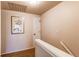 Hallway featuring a white railing, neutral paint, and access to other rooms at 6839 E Briarwood Dr, Centennial, CO 80112