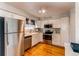 Modern kitchen featuring stainless steel appliances, white cabinets, and hardwood floors at 6839 E Briarwood Dr, Centennial, CO 80112