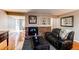 Living room with brick fireplace, hardwood floors, and leather furniture at 6839 E Briarwood Dr, Centennial, CO 80112