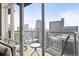 Balcony overlooking the city skyline with a glass railing and outdoor seating area at 891 14Th St # 2712, Denver, CO 80202