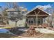 Exterior of the home from the backyard with a covered patio and stone fire pit, perfect for outdoor living at 27 Buckthorn Dr, Littleton, CO 80127