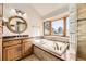 Bright bathroom featuring a soaking tub with a large window and a custom sink at 27 Buckthorn Dr, Littleton, CO 80127