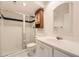 Well-lit bathroom featuring a glass enclosed shower, vanity with sink, toilet, and cabinet at 27 Buckthorn Dr, Littleton, CO 80127