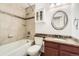 Charming bathroom featuring a tub-shower combo, vanity with sink, cabinet and mosaic tile accents at 27 Buckthorn Dr, Littleton, CO 80127