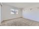 Bright, carpeted bedroom with a window, two floating shelves, and neutral walls at 27 Buckthorn Dr, Littleton, CO 80127