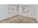 Sunlit bedroom with carpet, two windows, and minimalist shelving at 27 Buckthorn Dr, Littleton, CO 80127