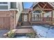 Welcoming covered entry porch with an American flag, leading to the front door of this charming residence at 27 Buckthorn Dr, Littleton, CO 80127