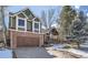 Charming two-story home with a brick and wood exterior, complemented by a paved driveway and a covered front porch at 27 Buckthorn Dr, Littleton, CO 80127