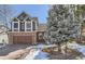 Charming two-story home featuring a brick and wood exterior, complemented by a paved driveway and mature landscaping at 27 Buckthorn Dr, Littleton, CO 80127